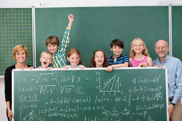 Schoolkinderen poseren met schoolbord — Stockfoto
