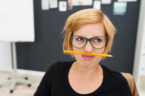 Vrouw zetten potlood tussen neus en lippen — Stockfoto