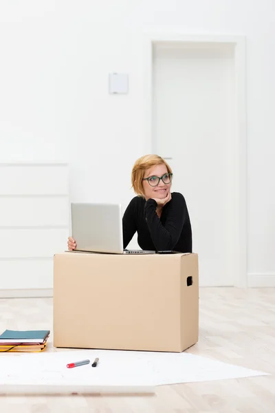 Mulher se mudando para casa trabalhando no laptop — Fotografia de Stock