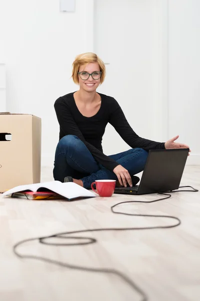Mulher no chão trabalhando no laptop — Fotografia de Stock