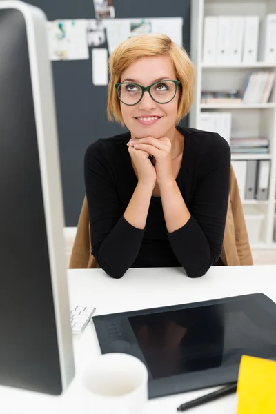Woman sitting daydreaming in office — Stock Photo, Image