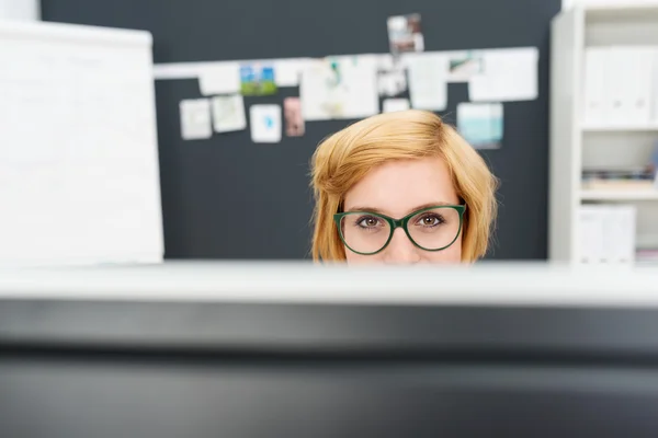 Geschäftsfrau schaut über den Computer hinweg — Stockfoto