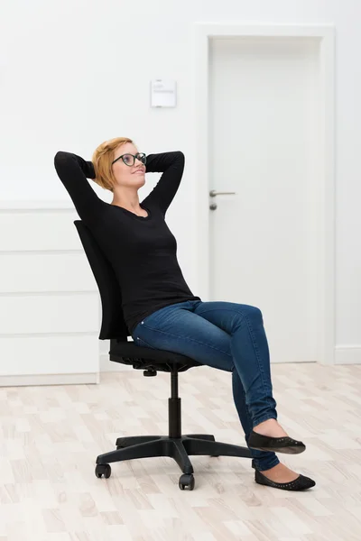 Mujer relajándose en una silla de oficina — Foto de Stock