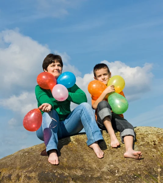 Familia feliz sentada en la piedra —  Fotos de Stock