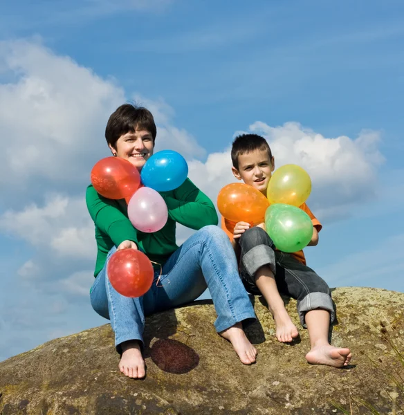 Familia feliz sentada en la piedra —  Fotos de Stock