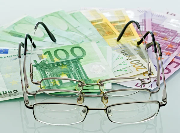Eyeglasses and currencies — Stock Photo, Image