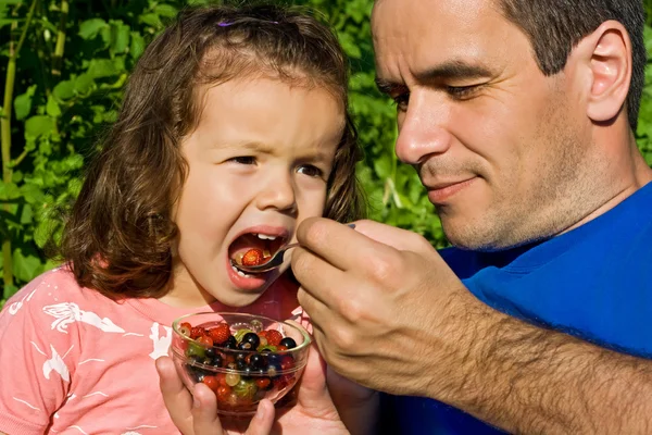 Маленька дівчинка їсть фрукти — стокове фото