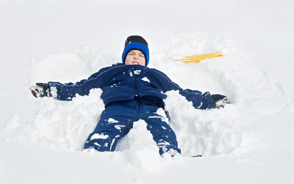 雪の中で横たわっている少年 — ストック写真