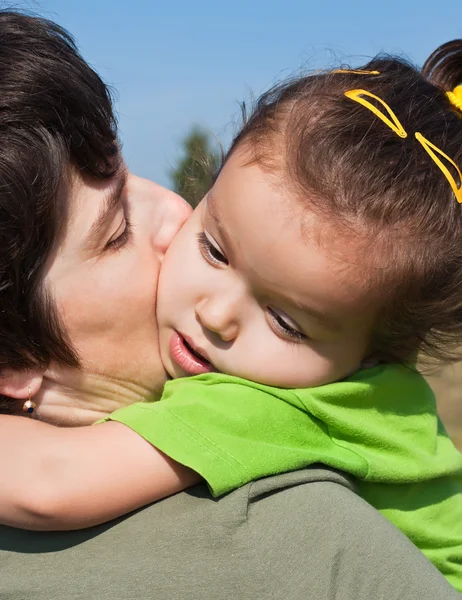 Niña en el hombro de su madre — Foto de Stock