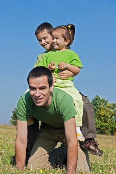 Família feliz brincando no prado — Fotografia de Stock