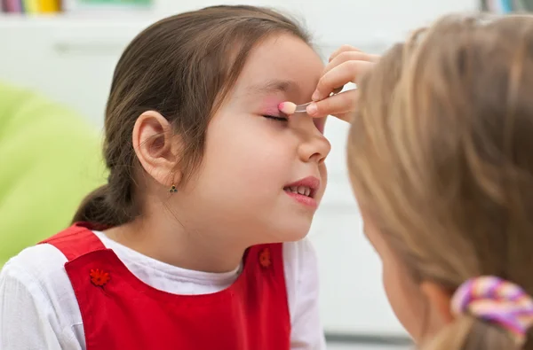 Niñas haciendo maquillaje Imágenes de stock libres de derechos