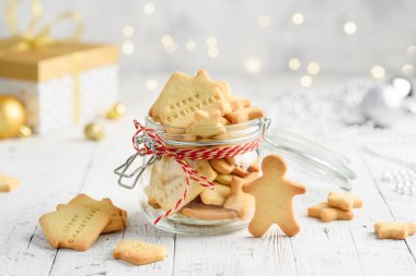 Beyaz ahşap bir masada kavanozdaki noel kurabiyeleri. Neşeli bir atmosfer. Seçici odak