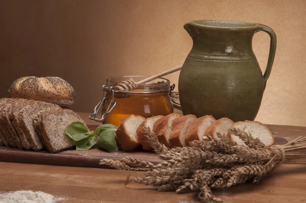 Rollos, pan y harina sobre mesa de madera — Foto de Stock