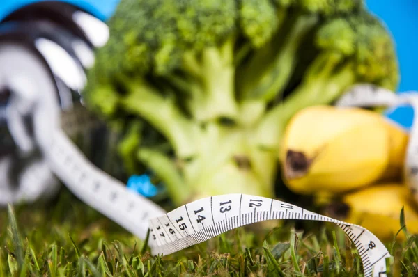 Fitness tema med blå bakgrund och grönt gräs — Stockfoto