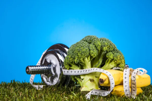 Fitness thema met blauwe achtergrond en groen gras — Stockfoto