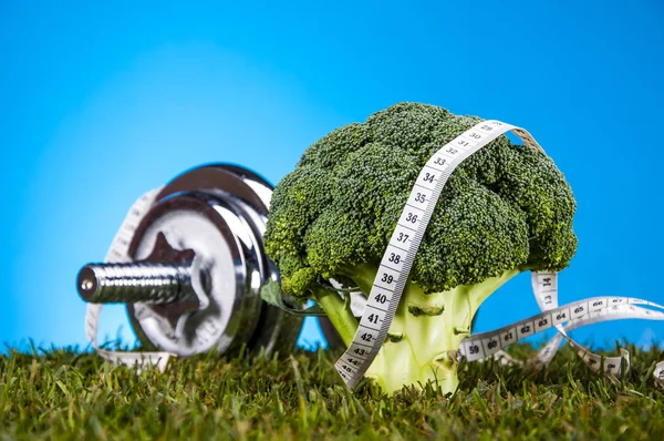 Fitness thema met blauwe achtergrond en groen gras — Stockfoto