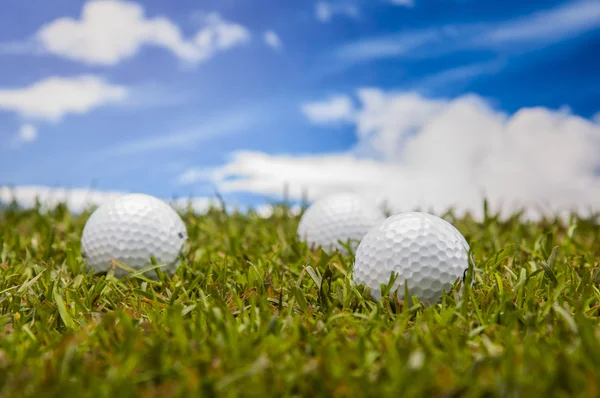 Golf balls, green grass, clouds background — Stock Photo, Image