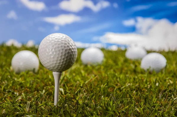 Golf balls, green grass, clouds background — Stock Photo, Image