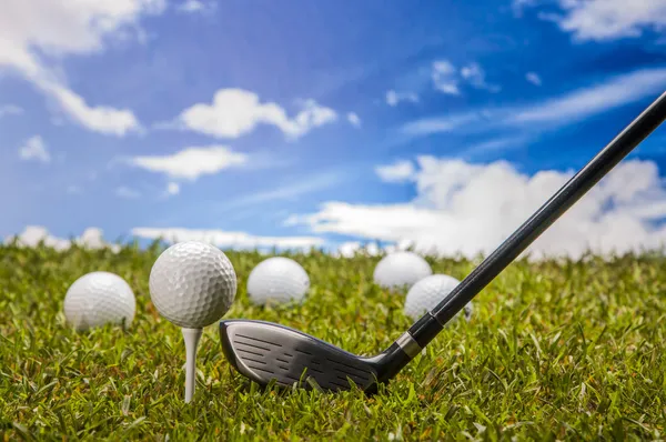 Golf labda, zöld fű, felhők háttér — Stock Fotó