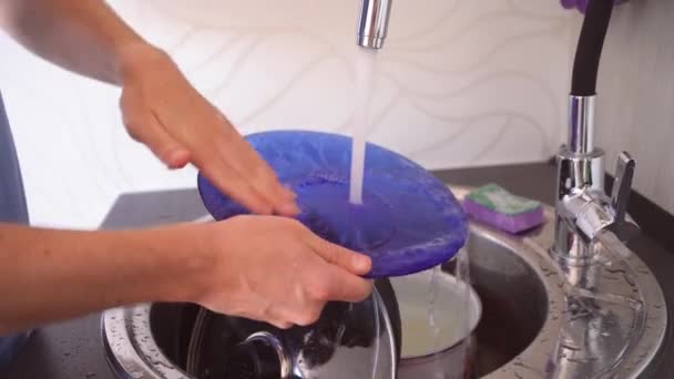 Mężczyzna zmywa naczynia gąbką. Człowiek zmywa detergent wodą z naczyń. Zbliżenie ręki człowieka, który zmywa naczynia. Facet po sobie pozmywa naczynia. — Wideo stockowe