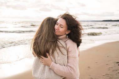 Rüzgarlı denizin kıyısında iki kızın samimi sonbahar yürüyüşü. Yetişkin kız kardeşler rüzgardan gelen battaniyelerle geziyorlar. Birbirine aşık bir çift sokakta yürüyor ve sarılıyor.