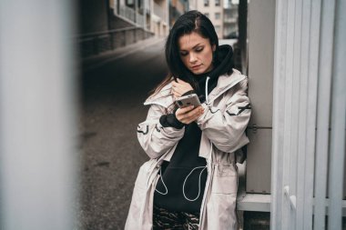 Güzel bir esmer telefona bakar. Kız birini bekliyor ve telefonuna bir mesaj yazıyor. Modern insanlarda sosyal ağlara bağımlılık.