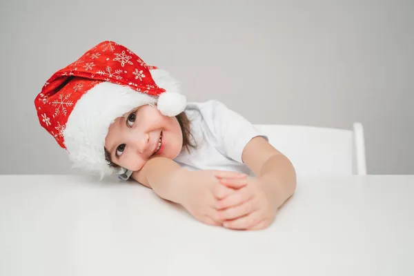 Ein Kind im Silvesterkostüm wartet auf die Feiertage. Ein freudiges Lächeln eines Mädchens im neuen Jahr. Neujahrsplakat mit Platz für Text lizenzfreie Stockbilder