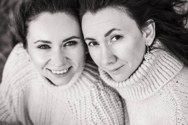 İki esmerin siyah beyaz portresi. Kızlar gözlerini kapattı. Kalın kazaklı güzel kadınlar..