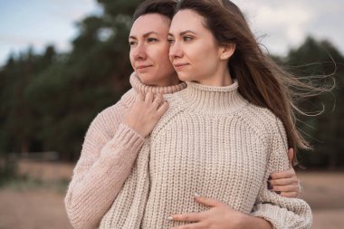 Aile ilişkileri hakkında bir pankart için hazır bir şablon. İki esmer kız sarılıyor. Metin için bej bir arka plan. Kardeşler arasındaki çok güven verici bir ilişki.