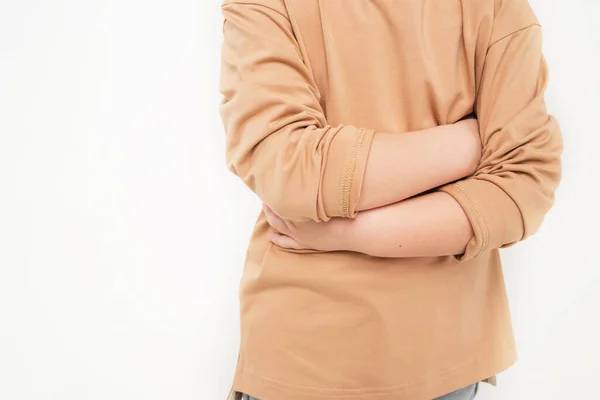 Close-up of the babys abdomen. The child is holding on to his stomach. A boy in a beige longsleeve. A child is waiting for something — Stock Photo, Image