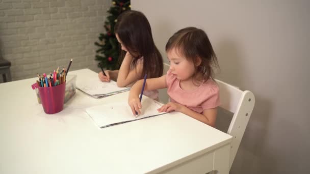 Vrolijke kinderen tekenen met potloden aan tafel. Voorschools thuisonderwijs. Creatieve ontwikkeling van kleuters — Stockvideo