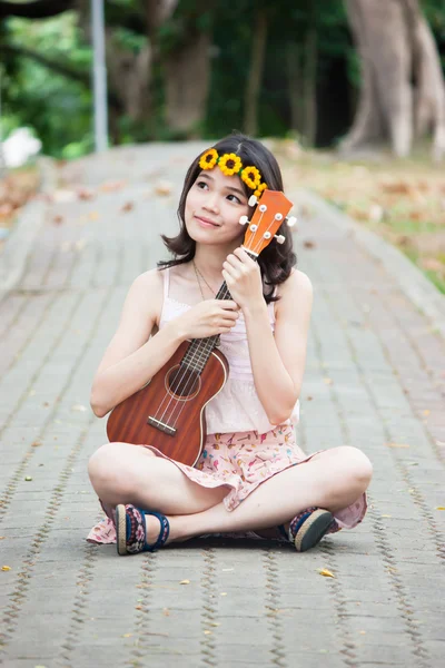 Chica asiática con ukelele guitarra al aire libre — Foto de Stock