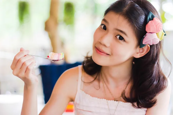 Girl posing eat a spoon of cake — Stock Photo, Image