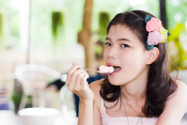 Girl posing eat a spoon of cake — Stock Photo, Image