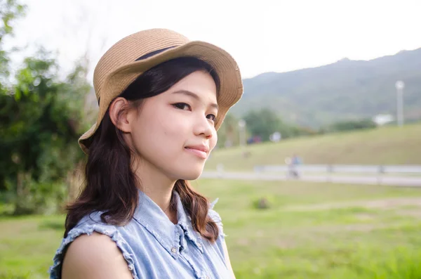 Porträtt av kvinnor poserar bär hatt utomhus grönt i parken — Stockfoto