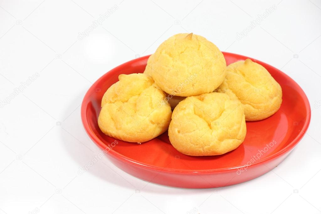 Cream puff with filling on red plate