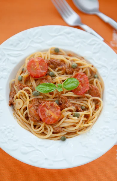 Spaghetti with tuna and tomatoes sauсe on orange background — Stock Photo, Image