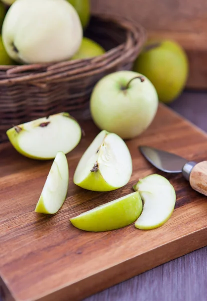 Plasterki zielonego jabłka na drewnianej desce do krojenia — Zdjęcie stockowe