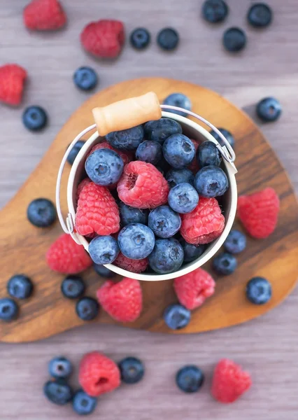 Fresh blueberries and raspberries in a bucket — Stock Photo, Image
