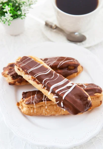 Choklad eclairs på vit platta — Stockfoto