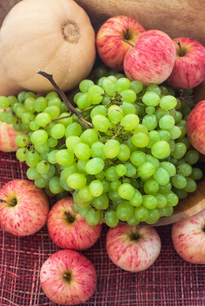 Осенние спелые фрукты и овощи - зеленый виноград, красные яблоки и тыквы — стоковое фото