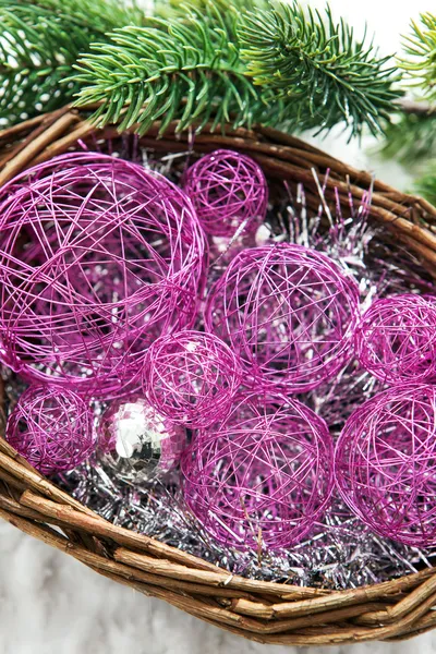 Christmas decorations in a basket and branch of spruce — Stock Photo, Image