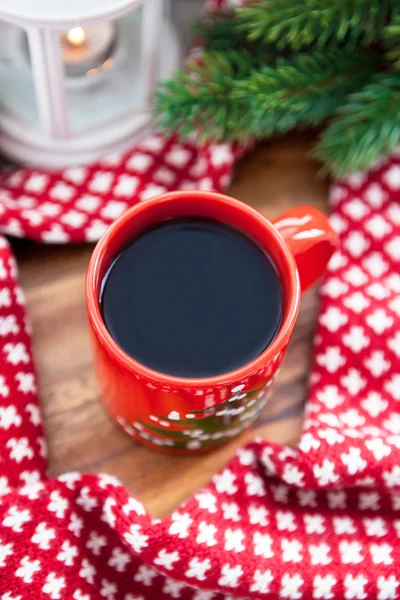Rote Kaffeetasse mit Kerze und Fichte auf dem Hintergrund — Stockfoto