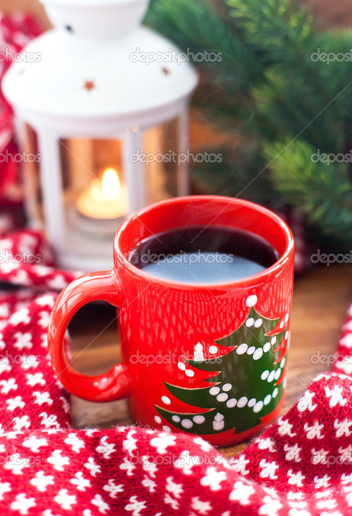 Red coffee cup with candle and spruce on the background