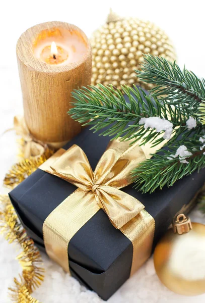 Composición navideña dorada con caja de regalo, vela y rama de —  Fotos de Stock