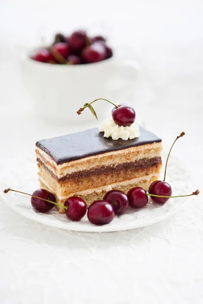 Del av opera tårta dekorerad med färska körsbär — Stockfoto
