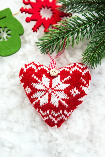 Stickad hjärtat på snön med fir-träd gren — Stockfoto