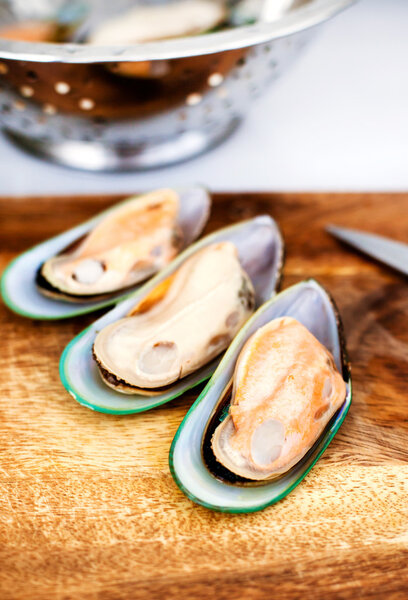 Raw giant mussels on a wooden cutting board