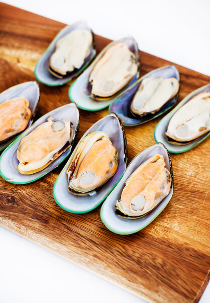 Raw giant mussels on a wooden board