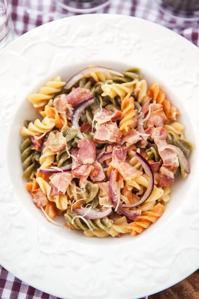 Fusilli pasta with bacon and onion — Stock Photo, Image